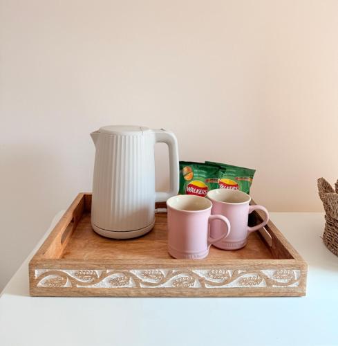 a coffee maker and two cups on a wooden tray at Quiet Cosy Room with Private Bathroom & LUSH Products in Rainham