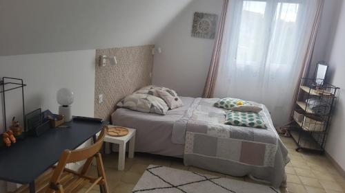 a small bedroom with a bed and a desk at Villa Carmen in Touques