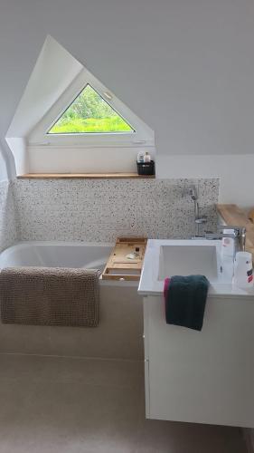 a bathroom with a tub and a sink with a window at Villa Carmen in Touques