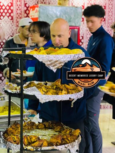 um homem de pé em frente a uma exibição de comida em Rum Visa Desert Luxury Camp em Wadi Rum