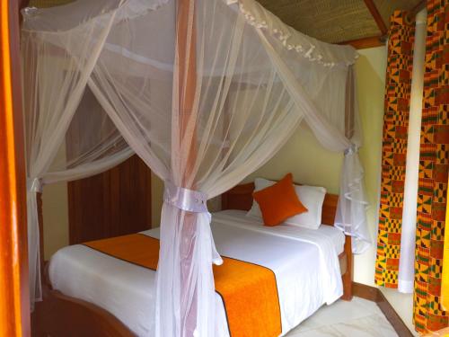 a bedroom with two beds and a canopy at New Court View Hotel in Masindi