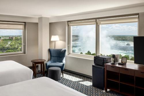 a hotel room with a bed and a desk and window at Wyndham Grand Fallsview Hotel in Niagara Falls