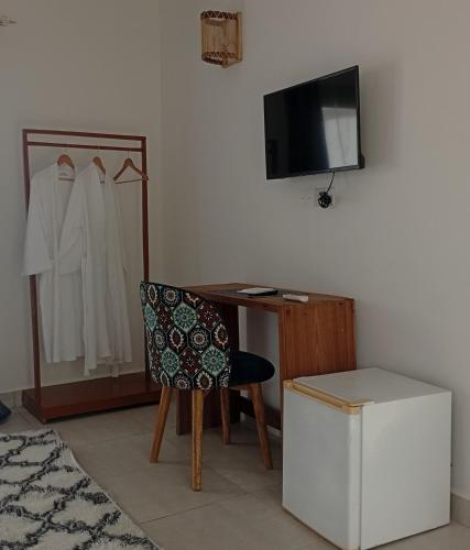 a room with a desk and a chair and a television at Ocean Bliss Beach Resort in Pongwe