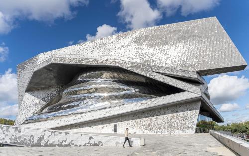 a man walks in front of a large concrete building at Studio number 5 in Pantin
