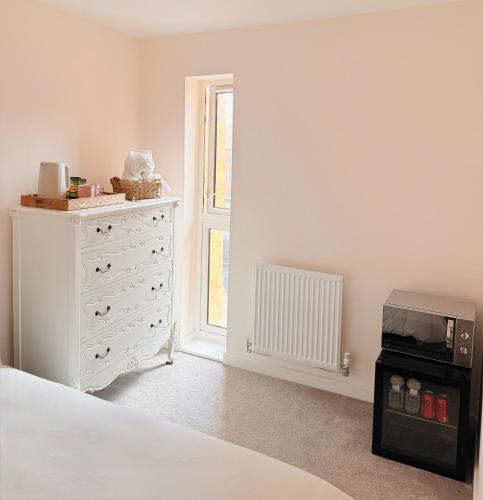 a bedroom with a white dresser and a bed at Quiet Cosy Room with Private Bathroom & LUSH Products in Rainham