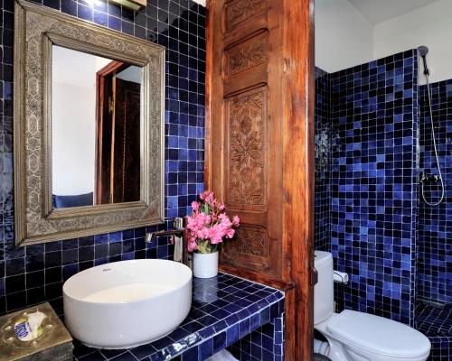 a blue tiled bathroom with a sink and a mirror at LHOSTEL à Casablanca in Casablanca