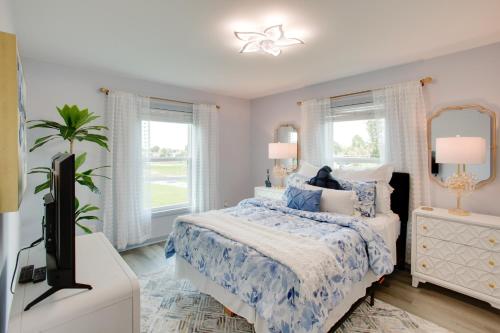 Sunny Fort Myers Home Golf, Shop and Relax! في فورت مايرز: غرفة نوم بسرير وتلفزيون ونوافذ