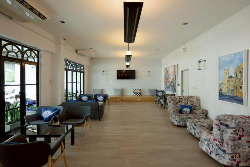 a waiting room with couches and chairs and a flat screen tv at Surachet at 257 Boutique House in Phuket