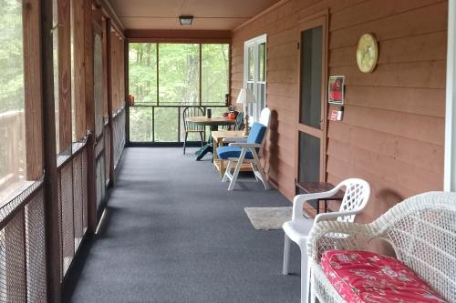 a porch with chairs and a table and a table at Cozy Hiawassee Cabin - 4 Mi to Lake Chatuge! in Hiawassee
