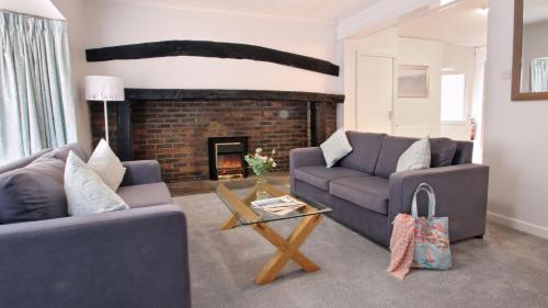 a living room with two couches and a fireplace at The Burrow at Forest Edge in Saint Leonards