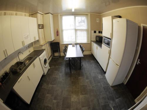 eine Küche mit weißen Geräten und einem Tisch darin in der Unterkunft Midtown Lodge in Nottingham