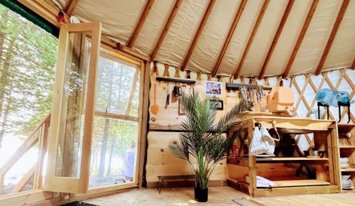 a room with a tent with a potted plant in it at Waterfront CedarGrove Yurt-Glamp in Red Bay