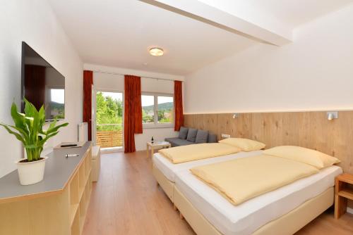 um quarto com uma cama grande e um sofá em Pension Gambrinus em Passau