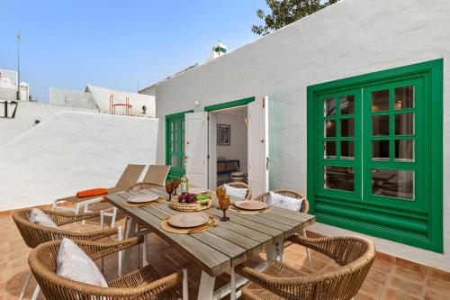 a wooden table and chairs on a patio at Oasis del Marinero by EscapeHome in Costa Teguise