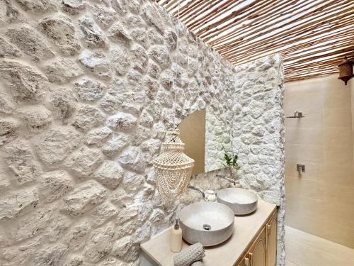 een stenen badkamer met 2 wastafels en een stenen muur bij Bali-Style Villa with Private Pool, 3 Min Walk to Bangrak Beach in Nathon Bay