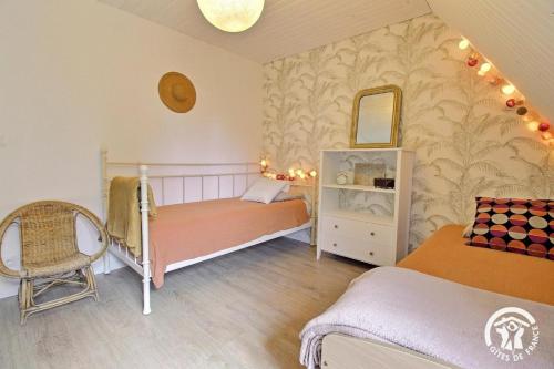 a small room with two beds and a chair at Ker gwennlo in Lignol