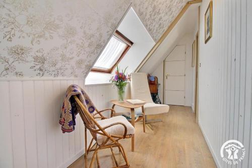 a attic room with a table and chairs and a window at Ker gwennlo in Lignol