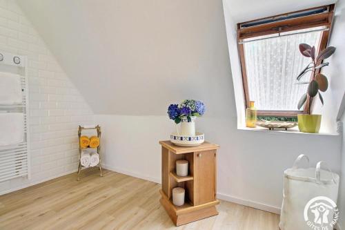 a room with a table with flowers and a window at Ker gwennlo in Lignol