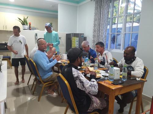 a group of people sitting around a table in a room at Oceanic Inn in Kolamaafushi