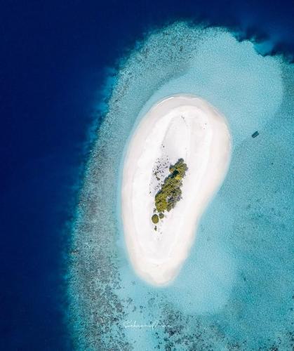 an island in the ocean with a rock in it at Oceanic Inn in Kolamaafushi