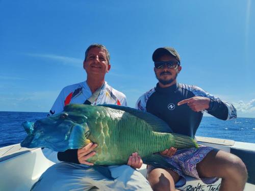 two men on a boat holding a large fish at Oceanic Inn in Kolamaafushi