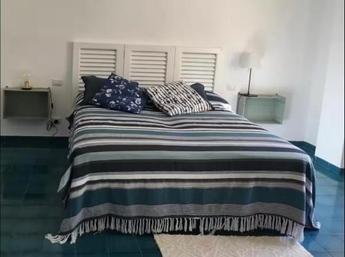 a bedroom with a large bed with pillows on it at Casa Carmela in Cozze