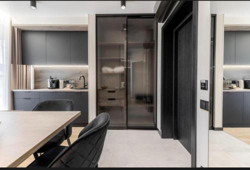 a kitchen with gray cabinets and a table and chairs at Преміальні апартаменти на березі озера Молодості in Bukovel