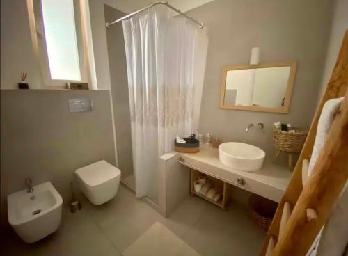 a bathroom with a toilet and a sink and a shower at Casa Carmela in Cozze