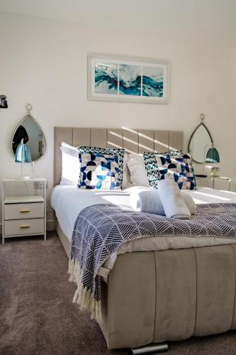 a bedroom with a large bed with blue and white pillows at Serene Contractor Pad - Slough, Heathrow, Windsor - Free Parking- WiFi - Sleeps 6-7 in Slough