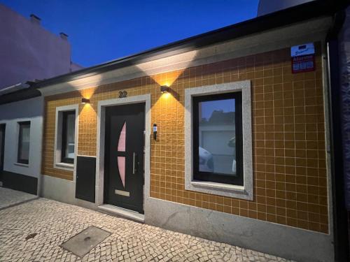 un edificio in mattoni con una porta e delle luci di Casinha Yellow - By the Sea a Ovar