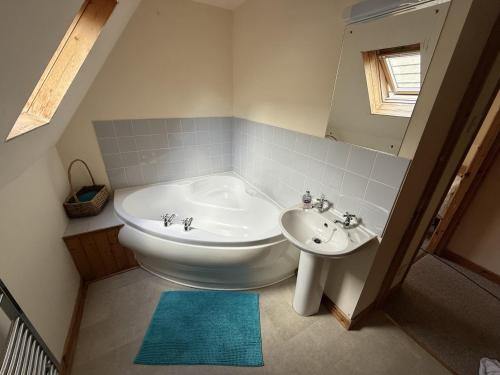 a bathroom with a white tub and a sink at Hembry Meadows in Callington