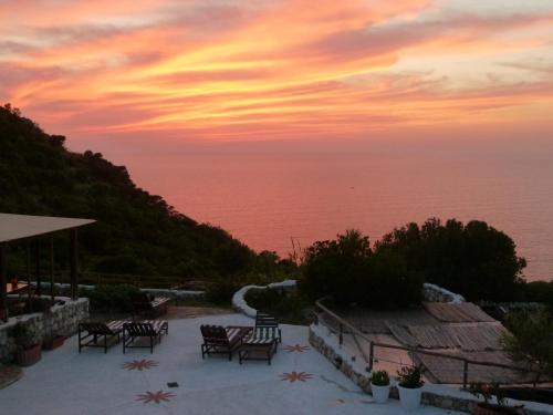a sunset over the ocean with tables and chairs at Il Cigno Affittacamere Bed & Breakfast in Ponza