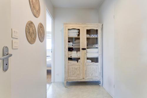 a room with a cabinet with dishes in it at Le cocon Champenois-Parking, centre & Tram in Reims