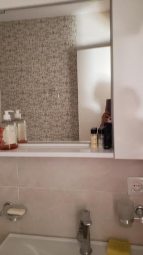 une salle de bain avec un miroir et un lavabo dans l'établissement apartment, à Tbilissi