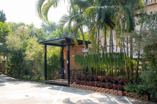 a gazebo with plants in it next to a building at Gita's House in Chiang Rai