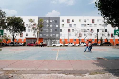 a couple of people walking around a parking lot at Excelente departamento in Mexico City