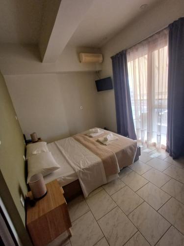 Un dormitorio con una cama y una mesa y una ventana. en Amalux, en Amaliás