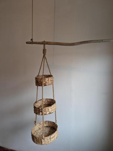 a wooden rack with baskets hanging on a wall at Don Jiménez Guesthouse in Puerto Jiménez
