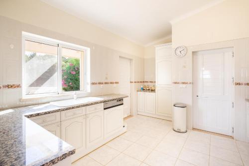 eine weiße Küche mit Spüle und Fenster in der Unterkunft 420 Villa Maren in Lagos