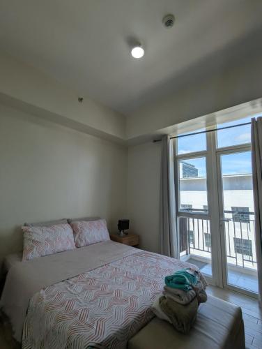 a bedroom with a bed and a large window at Saint Honore Megaworld in Iloilo City