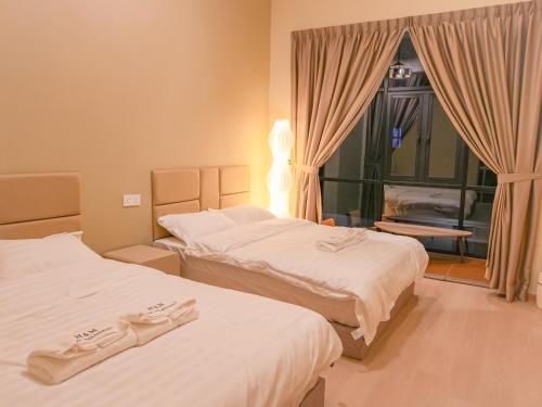 a hotel room with two beds and a window at Dreamwood Villa Sakeh in Muar