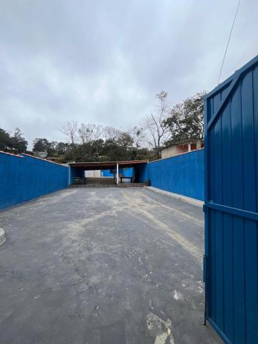 an empty parking lot next to a blue fence at Espaço tá moiado in Guarulhos