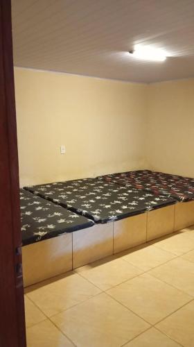 a bedroom with a bed in the corner of a room at Espaço tá moiado in Guarulhos