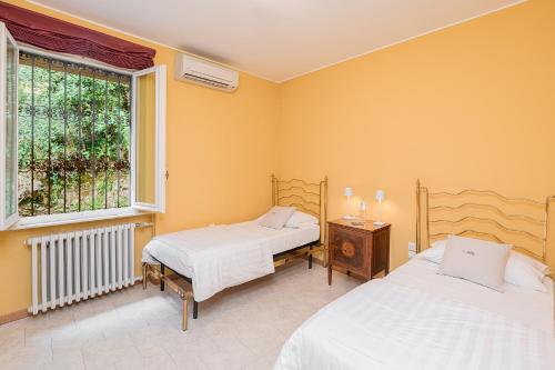 a bedroom with two beds and a window at Villa Belvedere by Comorooms in Como