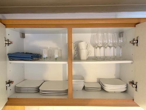 a cabinet filled with plates and wine glasses at Boho & Loft 2 Zimmer Parkplatz in Bad Hersfeld