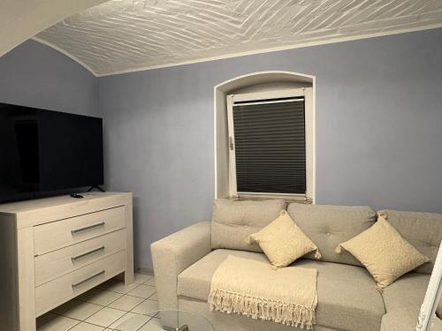 a living room with a couch and a tv at Boho & Loft 2 Zimmer Parkplatz in Bad Hersfeld