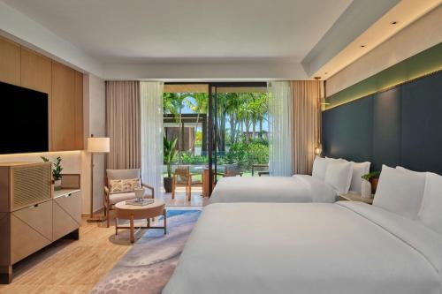 a hotel room with two beds and a television at The St. Regis Cap Cana Resort in Punta Cana