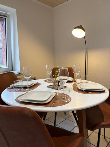 a table with chairs and a white table with wine glasses at Boho & Loft 2 Zimmer Parkplatz in Bad Hersfeld