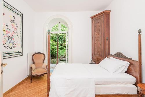 a bedroom with a bed and a chair at Villa Belvedere by Comorooms in Como