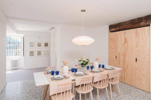 a white dining room with a table and chairs at Villa Belvedere by Comorooms in Como